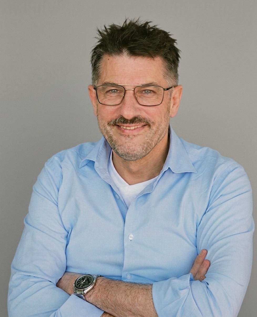 Ron Siedner, Bohabaita's advisor in Berlin, smiling in a light blue shirt