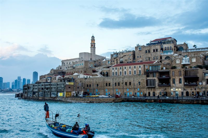 Jaffa's old city above the port, with a boat in the foreground