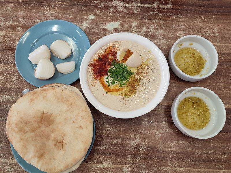Ein Teller Hummus mit Pita und Zwiebel bei Abu Hassan in Jaffa