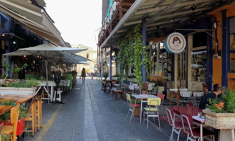 Tische und Stühle vor dem Café Puaa in einer Gasse des Flohmarkts in Jaffa