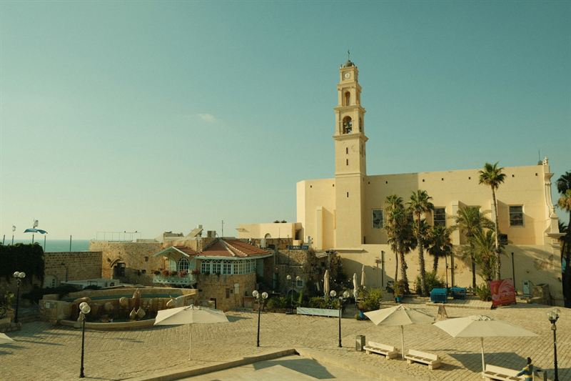 Der Glockenturm der Peterskirche in Alt-Jaffa, mit Palmen und Meer