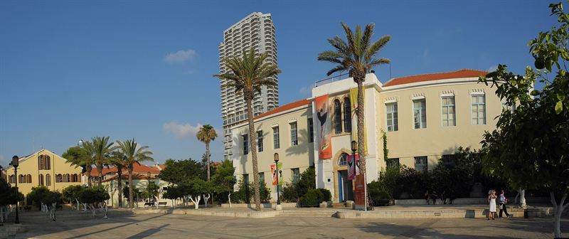 The square of the Suzanne Dellal Centre in Neve Tzedek, with palm trees and the old school building