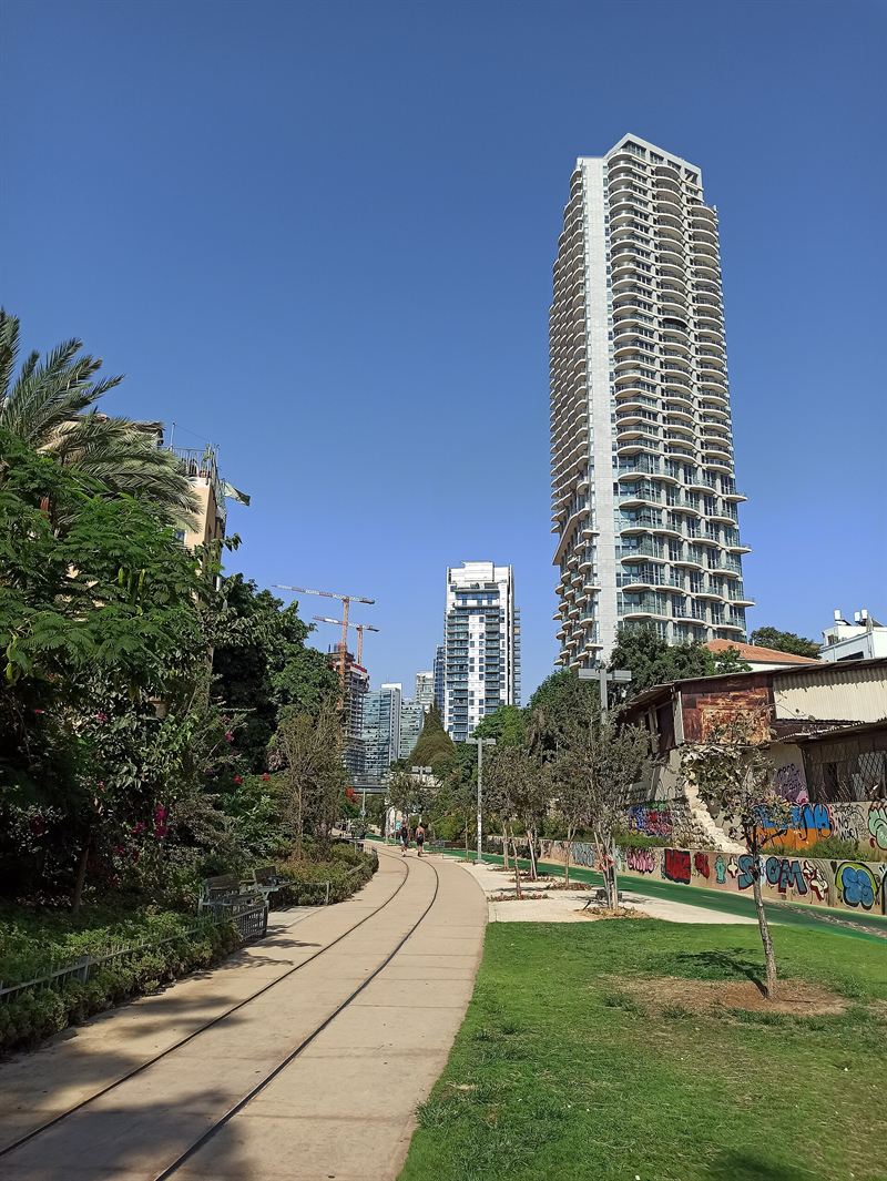 Der Weg durch den Park HaMesila, dahinter ein Hochhaus in Neve Tzedek